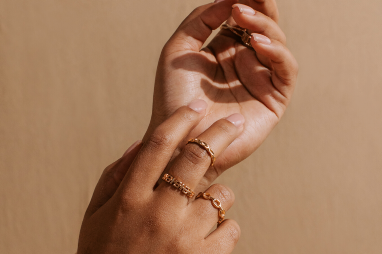 manos mujer con anillos de oro en diferentes dedos