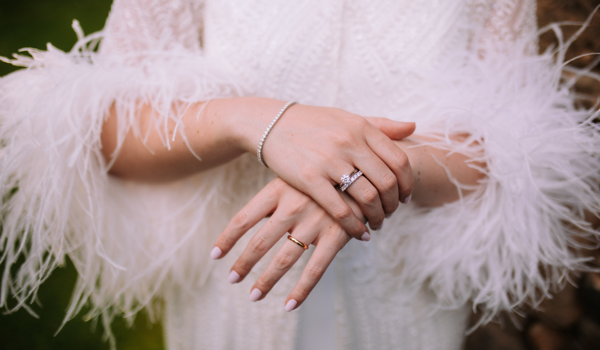 manos novia con anillos y pulsera con joyas Grau de boda