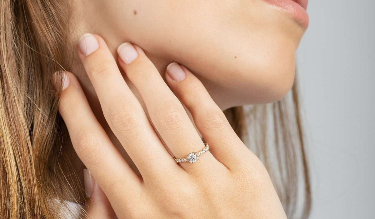 mano de mujer portando un anillo de compromiso en el dedo